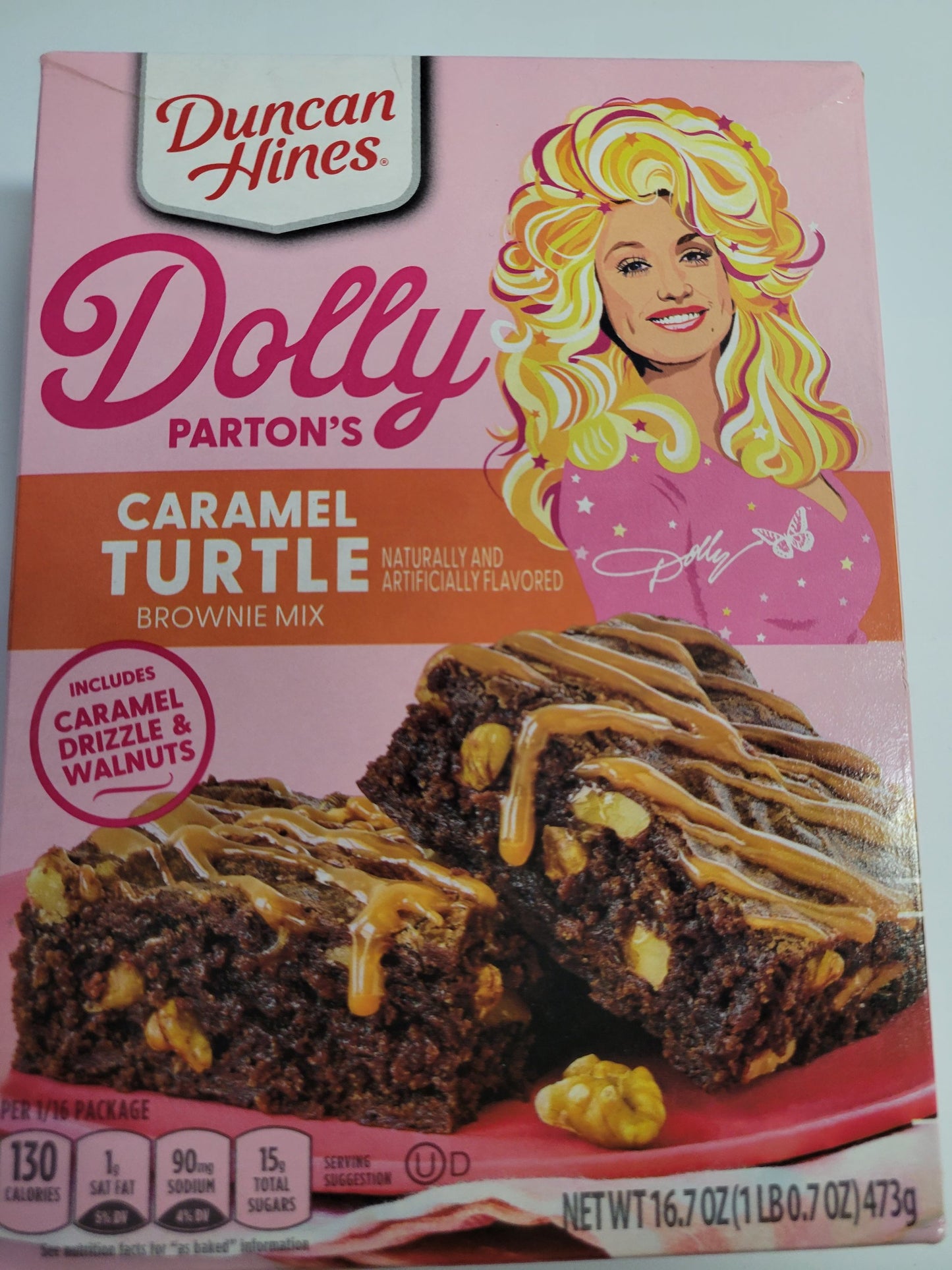 Duncan Hines Dolly Parton Brownie Bundle, 1 box 17.6 oz of Dolly Partons Fabulously Fudgy Brownie Mix, 1 box 16.7 oz of Dolly Parton Carmel Turtle Brownie Mix, 2 containers 16 oz of Dolly Partons Creamy Buttercream Frosting and 1 spatula