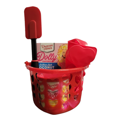 Dolly Parton Cake Gift Bundle for Valentine's Day, 1 15.25 oz box of cake mix, 1 16 oz container of frosting, 1 spatula, and a heart shaped basket